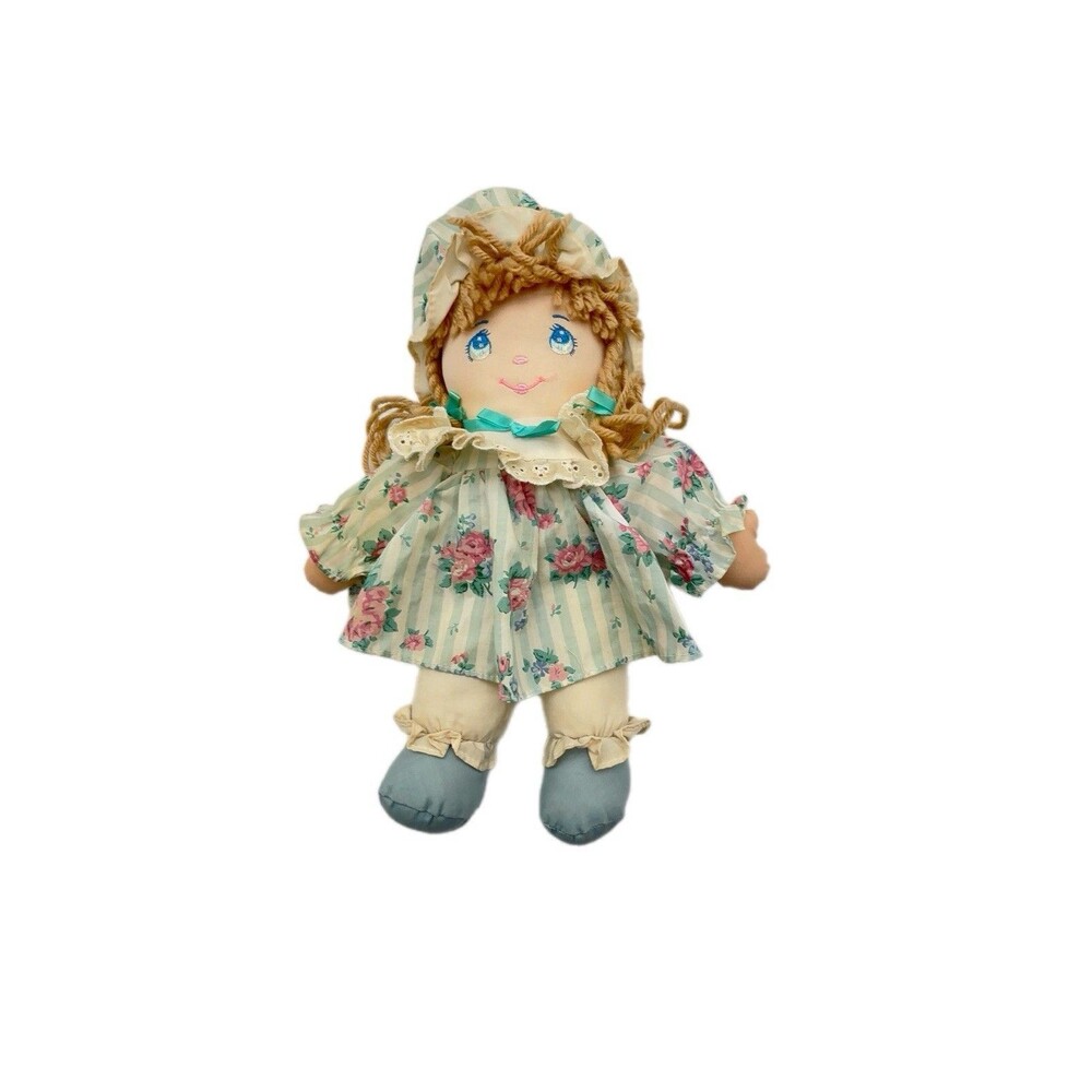 Vintage Commonwealth rag doll in a green and pink floral dress.